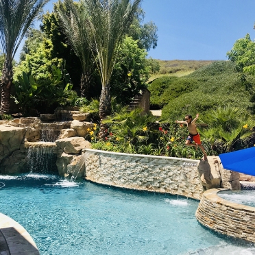 Swimming Pool with Rock Waterfall and Stone Retaining Wall