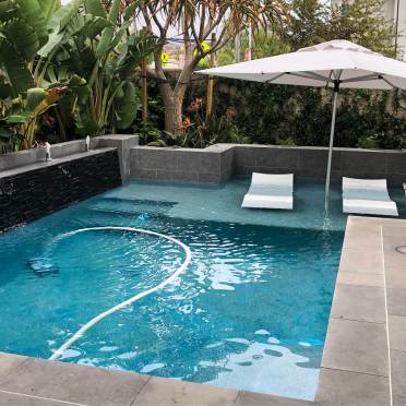 Geometric Swimming Pool with Reef Step and Black Tile Feature Wall